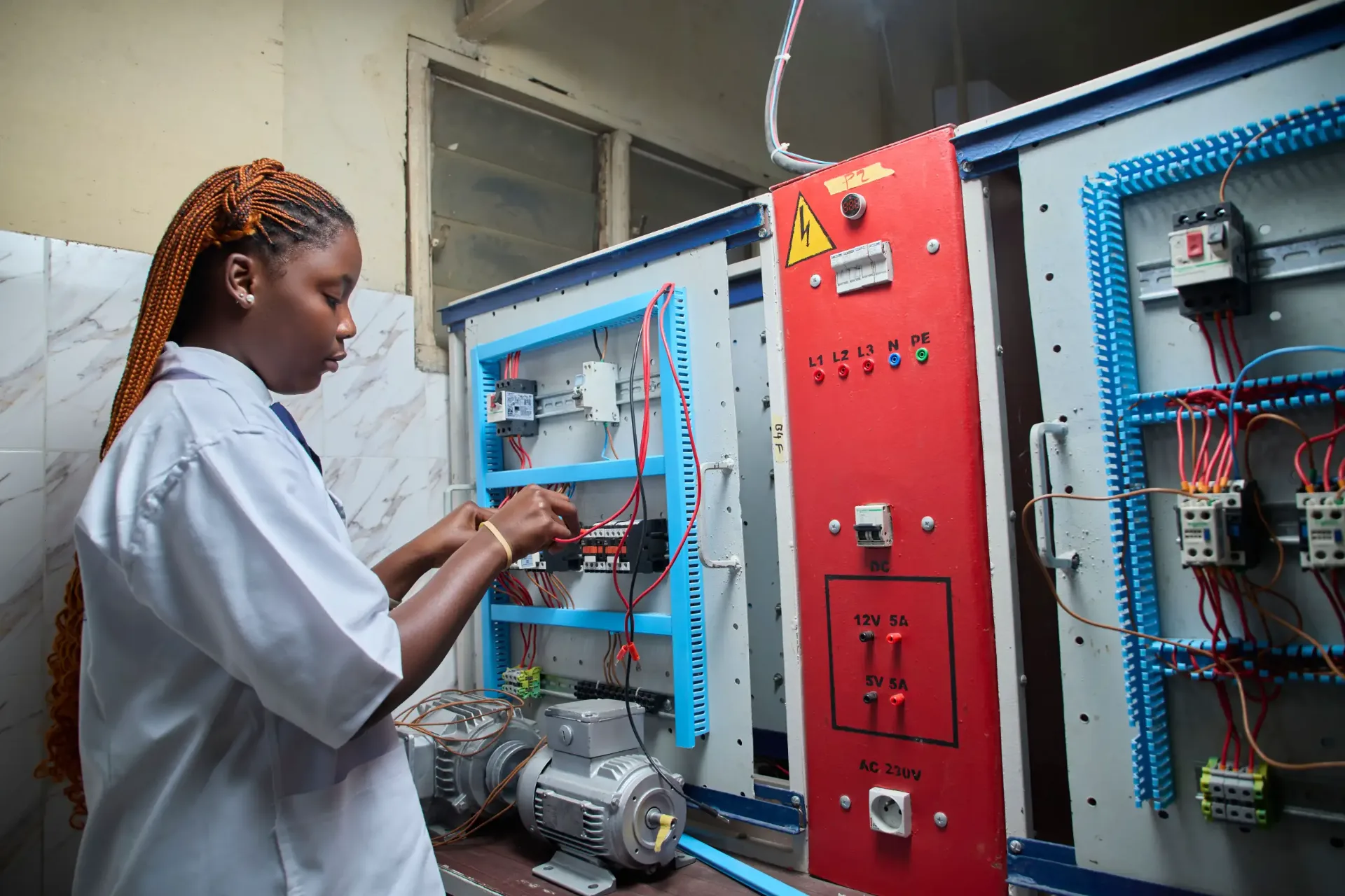 A student wiring a control panel in the school's electrical engineering laboratory